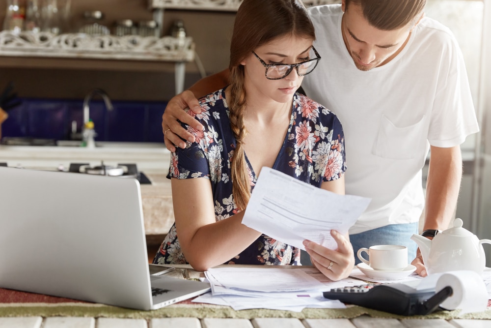 ¿Cómo pagar el IBI? Pareja estudiando el pago del Impuesto de Bienes Inmuebles.